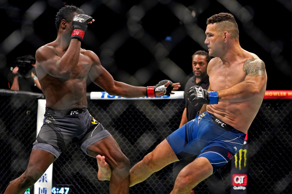 Apr 24, 2021; Jacksonville, Florida, USA; Chris Weidman (Blue Gloves) breaks his leg on his first kick against Uriah Hall (Red Gloves) during UFC 261 at VyStar Veterans Memorial Arena. Mandatory Credit: Jasen Vinlove-USA TODAY Sports