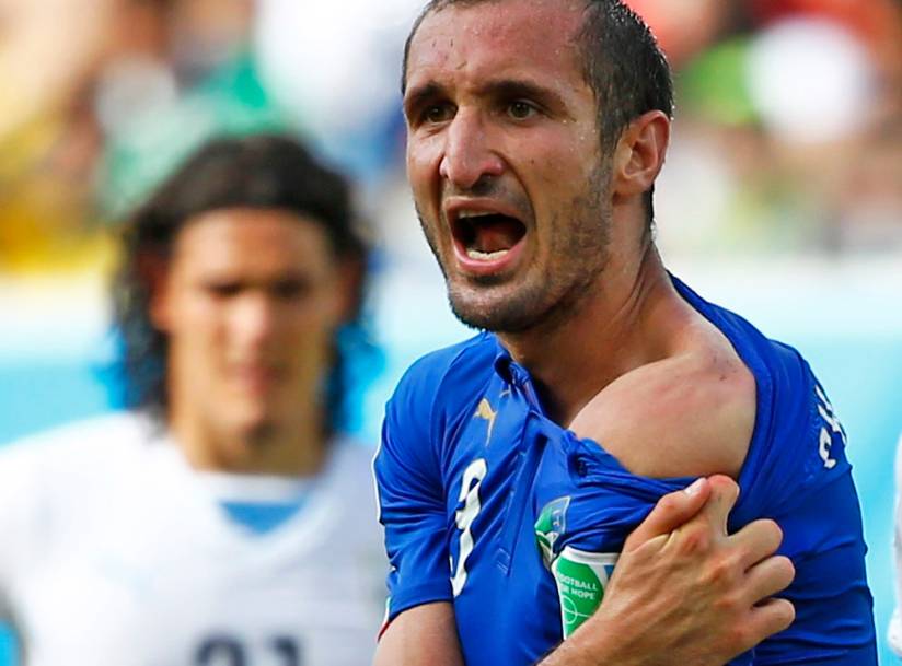 Italy's Giorgio Chiellini shows his shoulder, claiming he was bitten by Uruguay's Luis Suarez, during their 2014 World Cup Group D soccer match at the Dunas arena in Natal June 24, 2014.  REUTERS/Tony Gentile (BRAZIL  - Tags: SOCCER SPORT WORLD CUP TPX IMAGES OF THE DAY)   - RTR3VJ0U